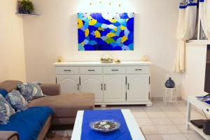 a living room with a couch and a painting on the wall at VILLA EDEN Gosier in Le Gosier +34 photos