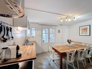 a kitchen and dining room with a wooden table and chairs at Maison No Catiau - De Panne in De Panne
