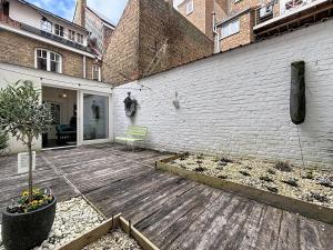 a backyard with a wooden deck next to a building at Maison No Catiau - De Panne in De Panne
