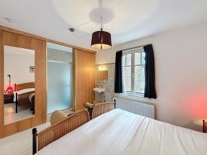 a bedroom with a bed and a mirror at Maison No Catiau - De Panne in De Panne