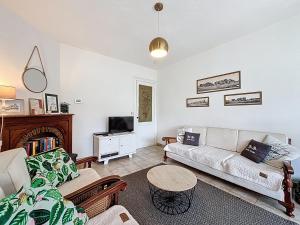 a living room with a couch and a tv at Maison No Catiau - De Panne in De Panne