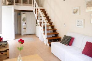 a living room with a white couch and stairs at Sunshine Home - Peaceful Garden Escape & Parking in Selianitika