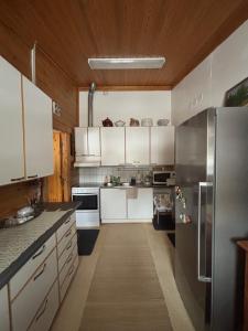 a kitchen with white cabinets and a stainless steel refrigerator at Villa Sillankorva in Viitasaari