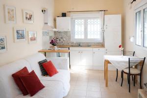 a living room with a white couch and a table at Sunshine Home - Peaceful Garden Escape & Parking in Selianitika