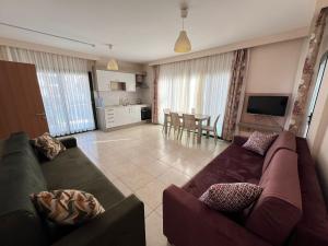 a living room with two couches and a kitchen at Marina Suite Otel in Silifke