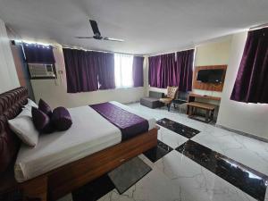 a bedroom with a large bed with purple pillows at Hotel O D S in Rāmgarh