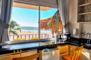 a kitchen with a view of the beach from a window at Saint Germain Kite Residence in Icaraí