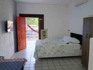 a bedroom with a bed and an open door at Flats Mundos Golfinhos in Pipa