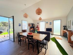a dining room and living room with a table and chairs at Les Alizés, 3 étoiles in La Brée-les-Bains