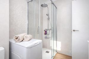 a white bathroom with a shower and a toilet at Amber Signature Apartment in Torrevieja +24 photos