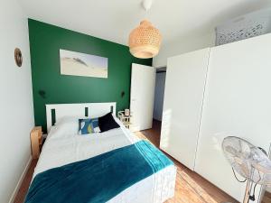 a bedroom with a bed and a green wall at Les Alizés, 3 étoiles in La Brée-les-Bains