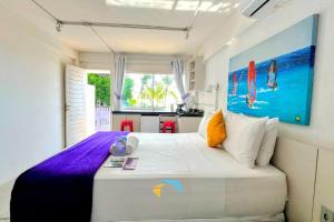 a bedroom with a large bed and a kitchen at Saint Germain Kite Residence in Icaraí