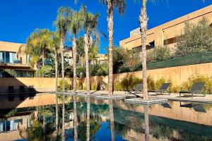 a pool with palm trees in front of a building at Marrakech Holiday in Marrakesh