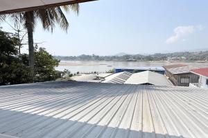 a metal roof with a view of a river and buildings at Bokeo Lodge & Restaurant in Ban Houayxay