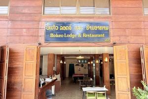 a restaurant with a sign on the side of a building at Bokeo Lodge & Restaurant in Ban Houayxay