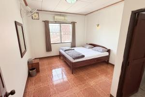 a small bedroom with a bed and a window at Bokeo Lodge & Restaurant in Ban Houayxay