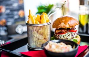 a sandwich and french fries on a table at Fordan Hotel Pécs in Pécs