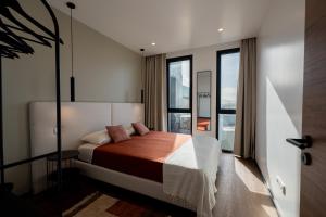 a bedroom with a bed and a large window at Essence Villas - Bath & Sunset in Ribeira Grande