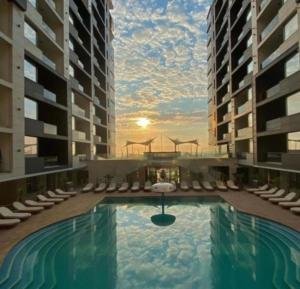 a swimming pool in a building with chairs and a sunset at Stefan Resort Mamaia Nord in Mamaia Sat/Năvodari