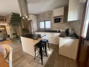 a kitchen with white cabinets and black counter tops at Casa Candida in Samaleo
