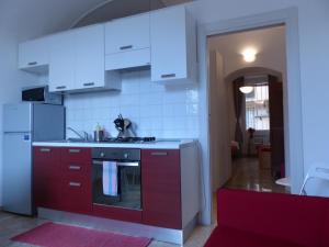 a kitchen with red cabinets and white appliances at Between Termini & Colosseo in Rome