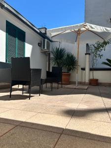 a group of chairs and an umbrella on a patio at B&B Crisalide in Putignano
