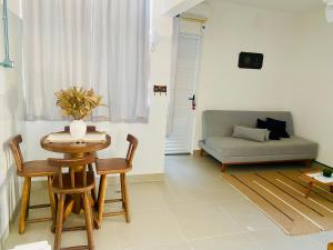 a living room with a table and chairs and a couch at Elegância Praia da Sereia in Vila Velha