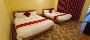 a room with two beds in a room at Hotel Lake shadow inn in Pokhara +3 photos