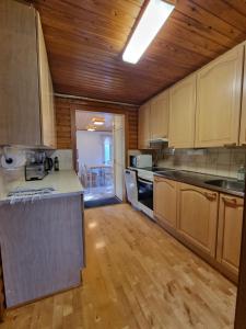 a large kitchen with wooden floors and a wooden ceiling at Narvijärven lomamökki in Rauma
