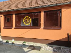 a building with a window with a yellow wheel on it at Apartman LIPA-Lipovac Bajakovo! Parking,Wi-Fi in Lipovac +4 photos