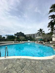 a large blue swimming pool with a building in the background at Timber Sanctuary at Rancamaya in Ciawi Bogor