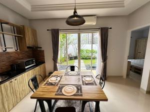 a dining room table with chairs in a kitchen at Timber Sanctuary at Rancamaya in Ciawi Bogor