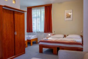 a hotel room with two beds and a window at Fordan Hotel Pécs in Pécs +56 photos