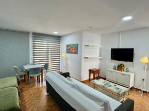 a living room with a couch and a tv and a table at Apartamentos Turísticos Yamasol in Fuengirola