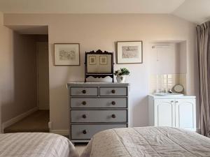 a bedroom with a dresser and a mirror at The View Cottage - Tennis Court - Nr Frome, Longleat in Frome +24 photos