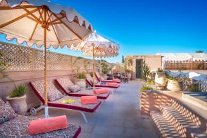 a row of chairs and umbrellas on a patio at Riad Anaqa in Marrakesh