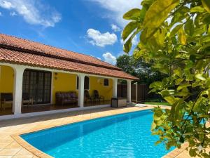 a villa with a swimming pool and a house at Pousada casa amarela Analândia SP in Analândia