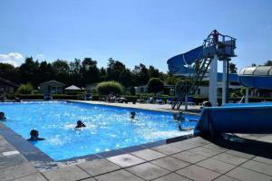 Eine Gruppe von Menschen schwimmt in einem Schwimmbecken in der Unterkunft Do's Chalets in Baarland