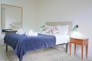 a bedroom with a bed with a blue blanket and a mirror at Gest Short Rent Siena 4 in Siena