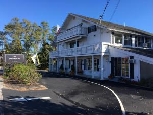 un edificio blanco con un cartel delante en The Beach Rose Inn, en Wells