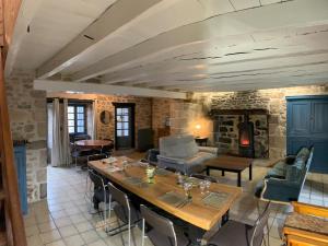 a living room with a table and a fireplace at Vacances au Lac de Saint-Pardoux in Compreignac