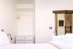 a bedroom with white walls and a white bed at Trilocale Luxury - 5 minuti Acquario di Genova in Genoa