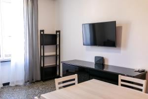 a room with a desk and a tv on a wall at Trilocale Luxury - 5 minuti Acquario di Genova in Genoa