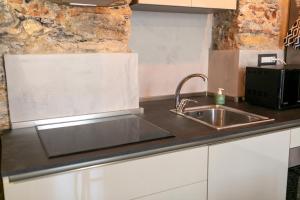 a kitchen with a sink and a counter top at Trilocale Luxury - 5 minuti Acquario di Genova in Genoa +9 photos