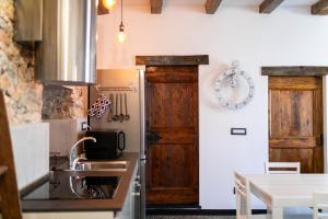 a kitchen with a sink and a refrigerator and a table at Trilocale Luxury - 5 minuti Acquario di Genova in Genoa