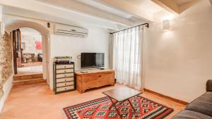 a living room with a couch and a tv at Lleo Eleven in Pollença