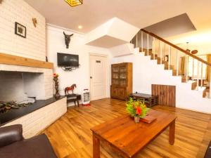 a living room with a fireplace and a table at Winterbourne Chalet in Coonoor