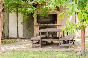 Ein Picknicktisch und Bänke vor einem Gebäude in der Unterkunft Finca La Vertiente in El Encón