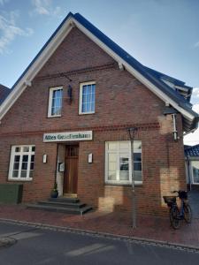 a brick building with a sign on the front of it at Altes Gesellenhaus in Dinklage