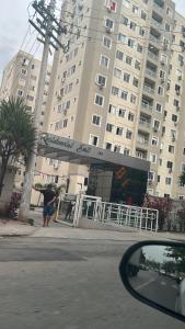 a person holding an umbrella in front of a building at Apartamento completo e confortável em Duque de Caxias in Duque de Caxias